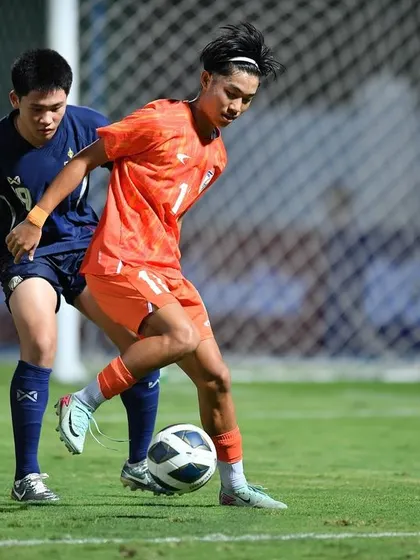 An Indian U17 player dribbles past a defender during a competitive match. This demonstrates the blend of speed, agility, and ball control that our training programs are designed to enhance.