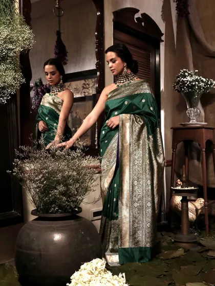An artistic shot using reflections and foliage to frame the model, creating a sense of looking into a hidden, beautiful world for Soho Begum.