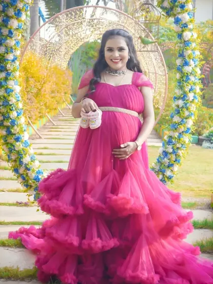 A beautiful portrait in a floral archway, with the mom-to-be holding up a pair of baby shoes. This combines a stunning location with a classic announcement prop.