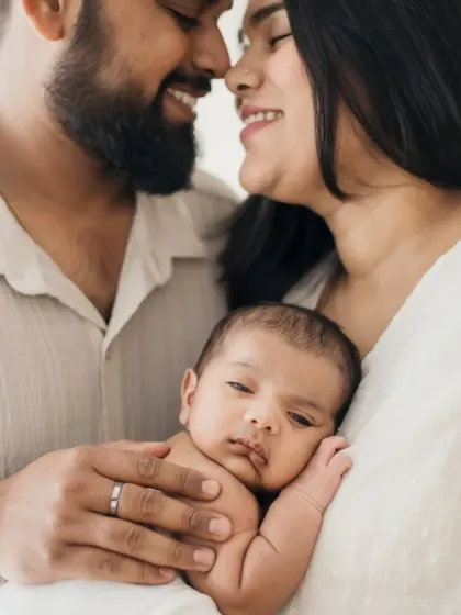 A close-up family portrait showing the intimate bond between parents and their new baby.