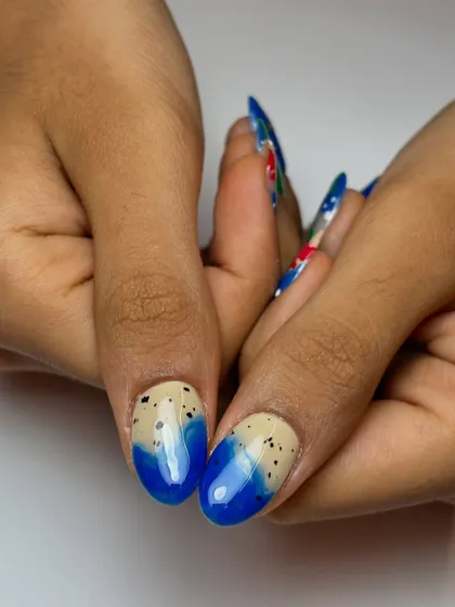 A detailed look at the ocean-themed nails, showing the texture of the "sand" and the deep blue of the water.