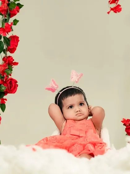 A relaxed little princess on her cloud of cotton, framed by beautiful red roses.