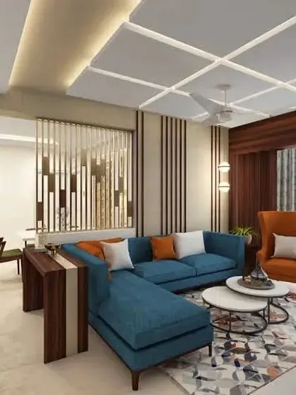This living room combines a bold blue sectional sofa with a warm orange accent chair for a vibrant look. A coffered ceiling design and a stylish partition add architectural interest and define the space.