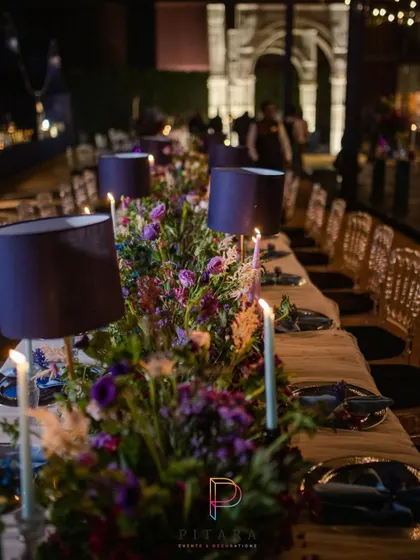 A long shot of the dining table, showing the repeating lampshades and floral runners that created a sense of rhythm and elegance down the length of the table.