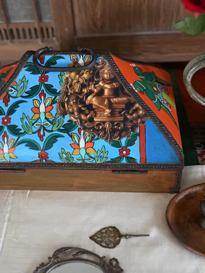 The side view of this memory box reveals a brass Ganesha fixture and floral patterns, adding a spiritual and decorative element to the design.