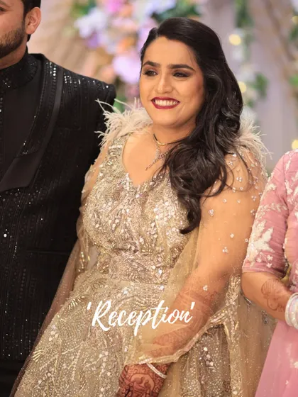 This image captures a bride's reception look. The makeup is glamorous yet elegant, with a bold red lip and glowing skin that perfectly complements her ornate golden gown.