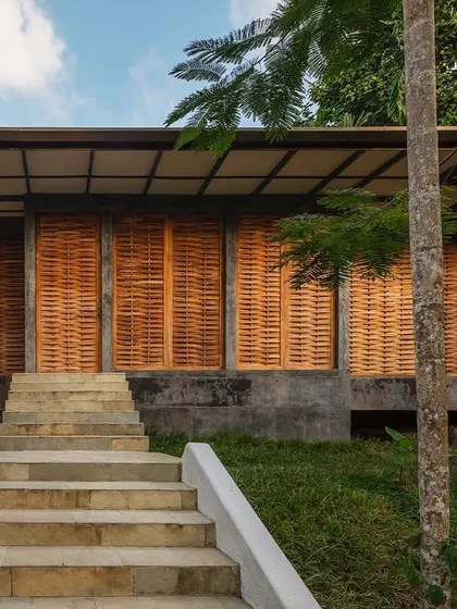 The facade of the Jalakara villa, with its woven teak wood screens closed to provide shade and privacy.
