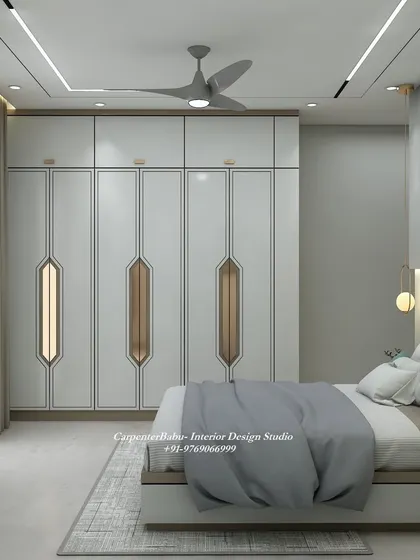 This view showcases the full-wall wardrobe with its modern, geometric-patterned handles, adding a unique and stylish touch to the room.