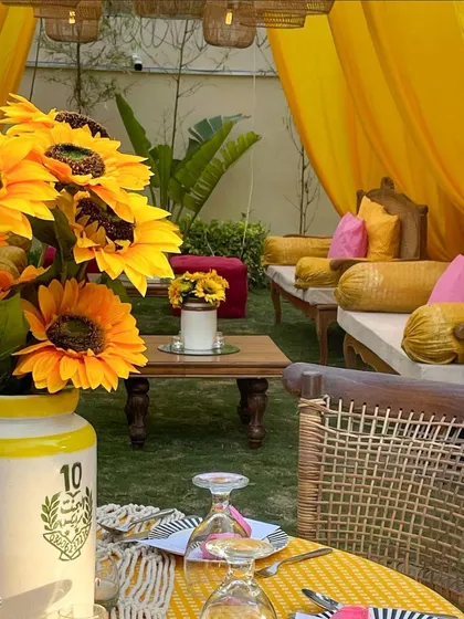 A close-up of a table setting from a sunflower-themed event. The cheerful yellow tones are carried through from the flowers to the table linens and napkins.