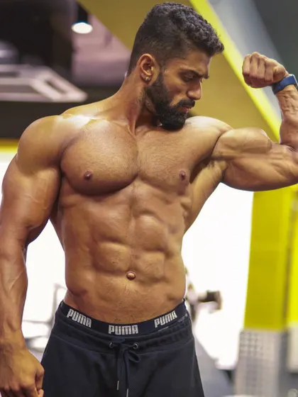 Flexing the bicep to show peak and definition. This is the result of targeted arm workouts, a key part of my strength training programs for building impressive muscle.
