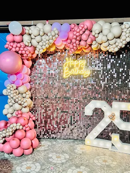 This photo captures the vibrant colors of the pink and chrome gold balloons against the sparkling backdrop.