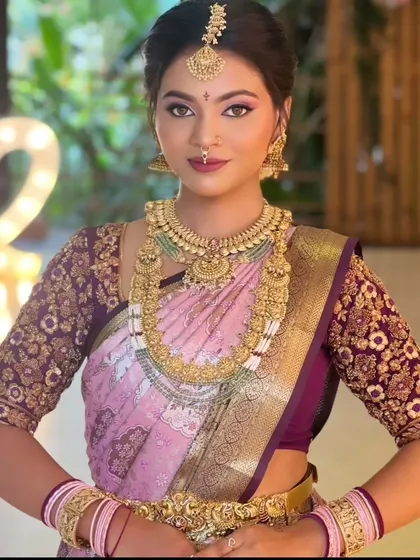 A close-up of the lavender and pink silk saree, showing the detailed gold jewelry and flawless makeup. This is a perfect inspiration for a soft and romantic bridal look.