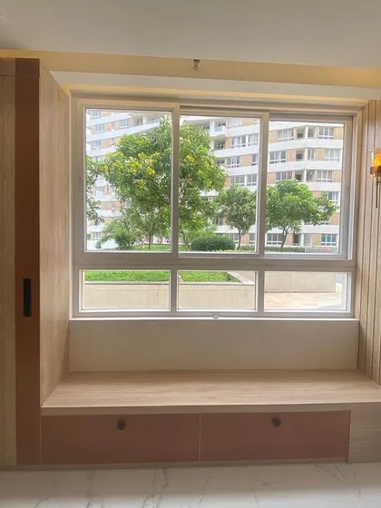 This cozy window nook with built-in storage is a perfect example of our space-saving design solutions. The wood paneling and warm lighting make it an inviting spot to relax.