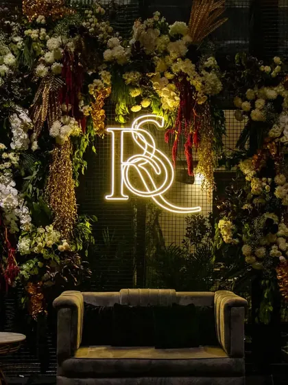 The full view of the floral photo wall with the glowing neon monogram. This installation provided a popular and highly shareable focal point for guests at the cocktail event.
