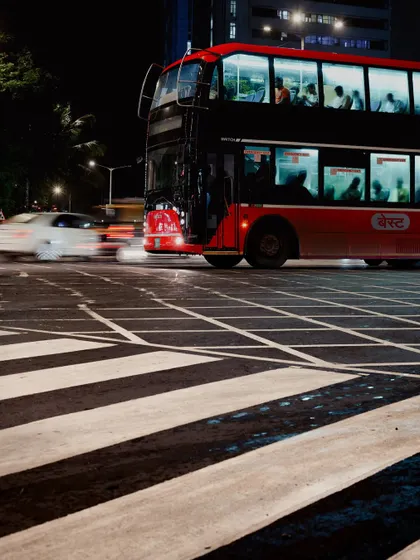 A series of night shots from the rainy streets of Mumbai, featuring motion-blurred double-decker buses and cars. These images capture the vibrant, electric energy of the city after dark.