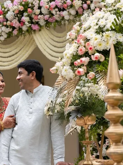 A heartwarming moment between a mother and daughter at a traditional ear piercing ceremony. The beautiful floral decor and their happy expressions make this a cherished memory.