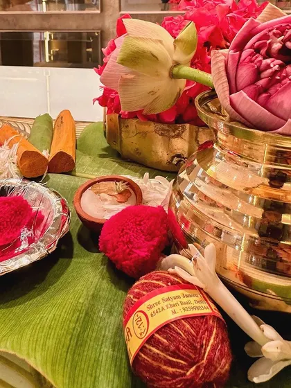 A detail shot of puja items, including sandalwood sticks, sacred thread (kalava), and lotus flowers. We ensure every element is authentic and beautifully presented.