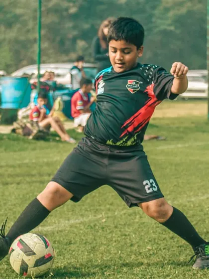 A young player lines up a pass, demonstrating good form and technique.
