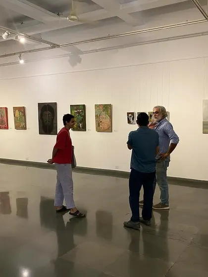Visitors in conversation at the 'ME, AMMA, WE' exhibition.