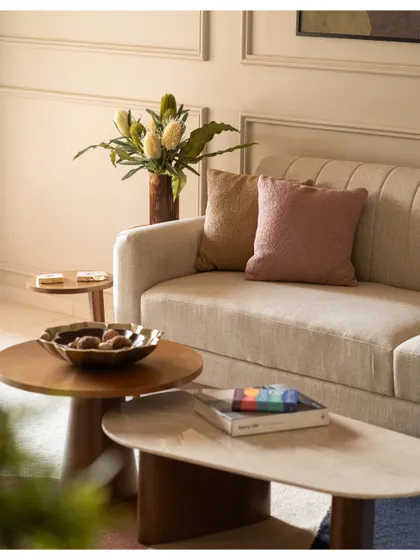 We focused on texture in this living room, with a comfortable cream sofa, nested coffee tables in wood and marble, and soft throw pillows.