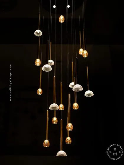 This cluster pendant features a mix of gold-toned rods with textured glass shades, some resembling pineapples and others simple domes. The combination creates a visually interesting and warm installation for any corner that needs a lift.