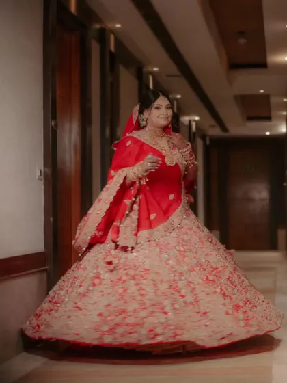 A full-length shot of Shalini, her red and cream lehenga twirling, captured in a grand hotel corridor.