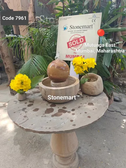 Another view of the small Rainbow Sandstone fountain on a pedestal table, demonstrating its versatility for display.