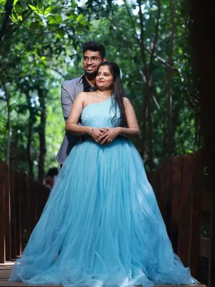 A sweet couple's portrait on a wooden bridge. The light blue gown adds a touch of softness and romance to the scene.