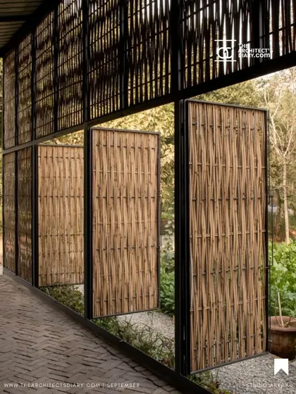 Pivoting bamboo-clad doors at the Artist Residency open up to the garden. These custom fixtures allow the inhabitants to control the level of openness and porosity, transforming the boundary between the interior studio and the exterior landscape.