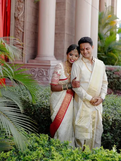 A happy, relaxed portrait of the couple in a garden setting, their smiles reflecting the joy of their wedding day.