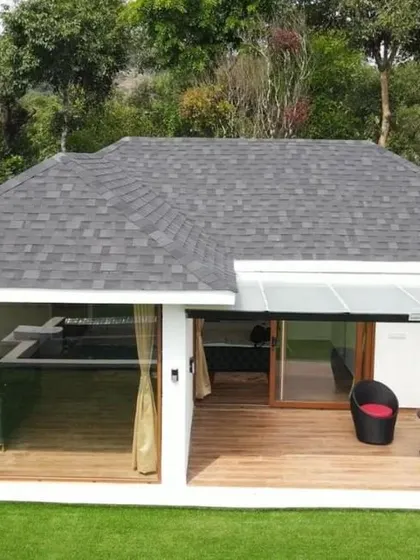 A modern cottage at Panorama Peaks, Coorg, with a private deck and large glass windows to maximize the stunning mountain views.