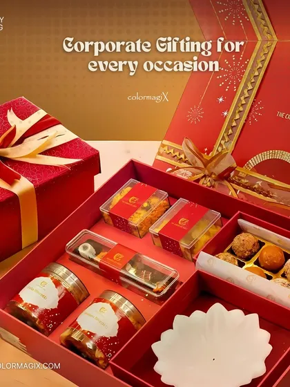 An open view of our red corporate gift box, revealing a selection of sweets, chocolates, dry fruits, and a decorative diya. It's a complete festive package for any occasion.