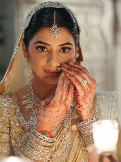 A beautiful close-up of the bride adjusting her nose ring, a delicate and traditional getting-ready moment.