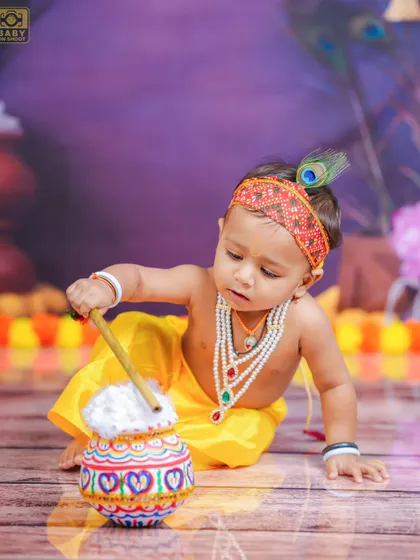 Focused on his pot of butter, this little Krishna is lost in his own world. These are the candid moments that families cherish forever.