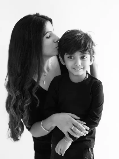 A quiet, loving kiss from a mother to her son. This black and white photo beautifully captures the tenderness and affection in their relationship.
