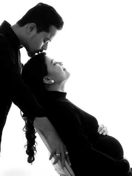 An intimate black and white portrait capturing a tender kiss on the forehead. This style focuses purely on the emotion and connection between the couple.
