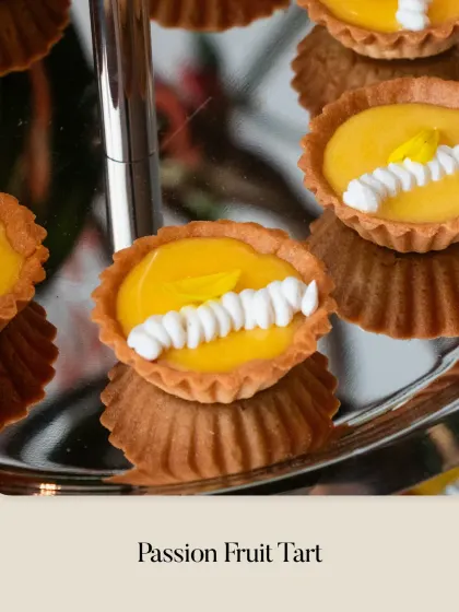 A vibrant and tropical Passion Fruit Tart, with a smooth, tangy filling and delicate piped cream decoration.