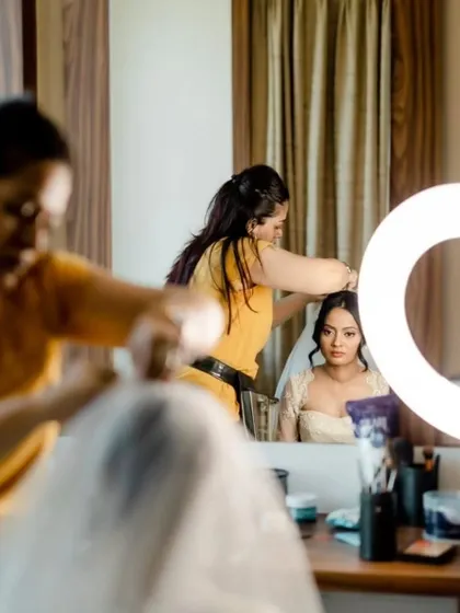 A glimpse into my setup while getting a bride ready. You can see her reflection in the mirror as I work on her hair, with all my tools ready to create the perfect look.