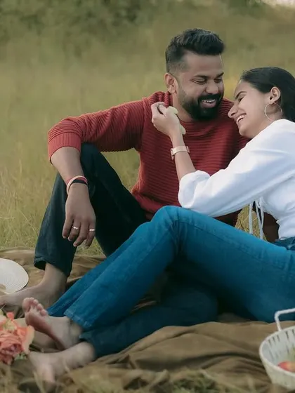 A playful and candid moment from a picnic setup, showing the fun and laughter shared between the couple.