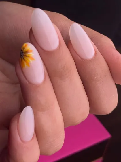 A touch of sunshine on your fingertips. This simple yet beautiful design features a single, hand-painted sunflower on an otherwise clean and classic nude manicure, showing how a small detail can make a big impact.