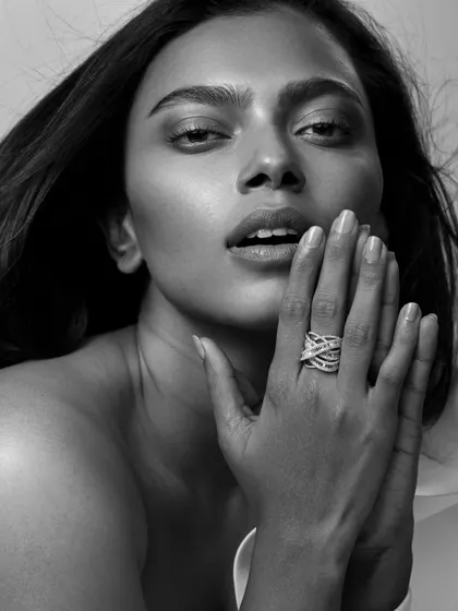 A soft and expressive shot focusing on a statement diamond ring. The model's pose feels natural and alluring, drawing attention to the jewelry in an organic way.