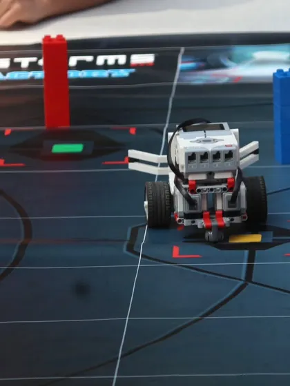 A LEGO Mindstorms robot positioned on a challenge mat during an IRO orientation. This demonstrates the type of advanced robotics our students learn to build and program.