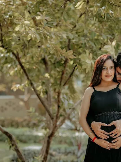 The classic heart-hands pose over the baby bump, done as a couple. This is a sweet and popular way to show your love for your growing family.