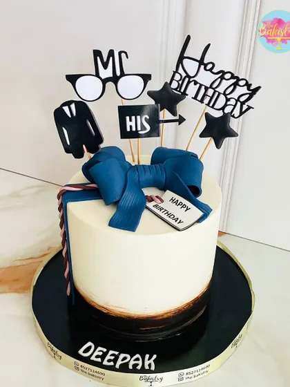 A dapper cake for Deepak, featuring a crisp white shirt design with a blue bow tie and other stylish toppers.