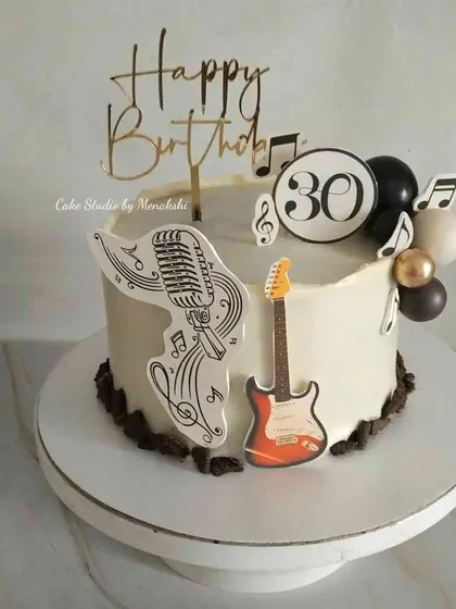 A 30th birthday cake for a music lover. The design includes a guitar, a vintage microphone, and musical notes to celebrate his passion.