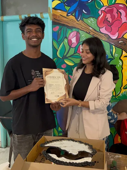 A smiling participant and his unique black and white resin clock, after a successful workshop session.