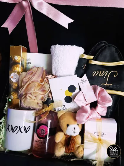A personalized birthday hamper featuring an 'xoxo' mug, a teddy bear, The Body Shop shower gel, and a custom-embroidered pouch.