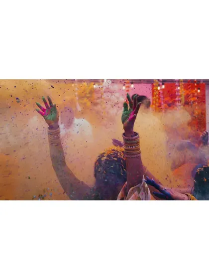 This image is pure celebration. The hands raised in the air, covered in the bright powders of the festival, symbolize the collective joy and vibrant spirit of the wedding festivities.