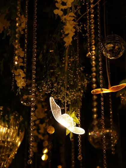 Another enchanting detail of the sangeet ceiling, with glowing butterflies and disco balls nestled among the foliage.