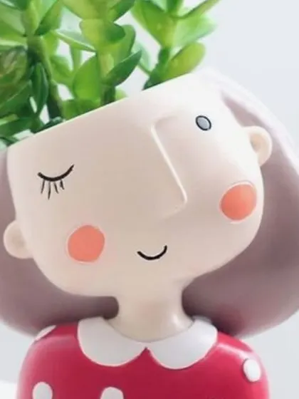 A cute and quirky planter of a winking girl in a red polka-dot dress, guaranteed to bring a smile to your face.